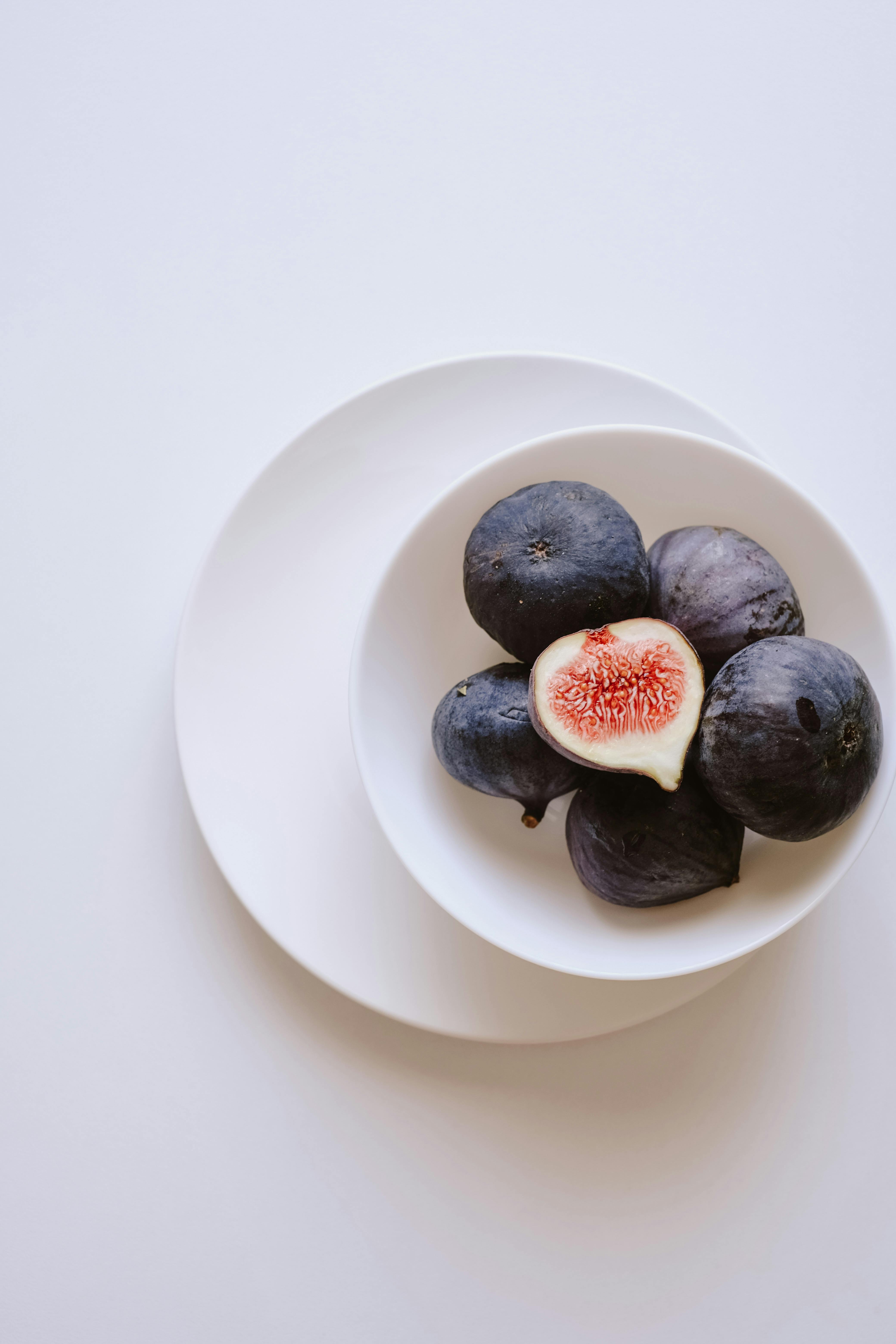 Elegant arrangement of fresh figs on a white plate highlighting simplicity and nutrition.